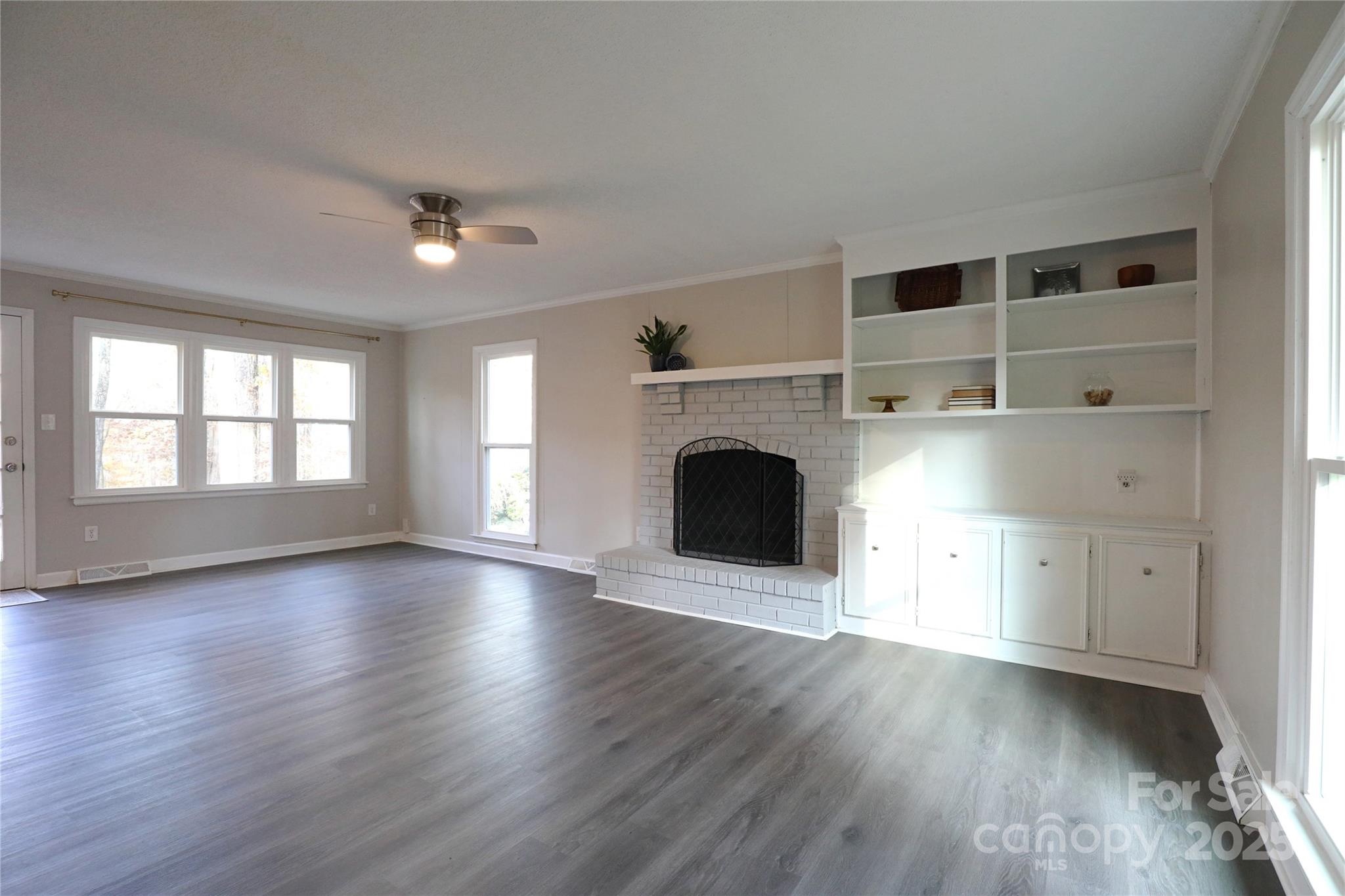 14027 Hackamore Drive Matthews, NC 28105 - Photo 2 of 29 an empty room with wooden floor a fireplace and windows