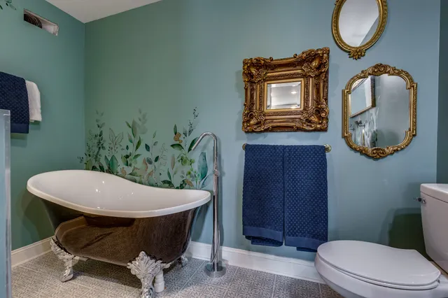 a bathroom with a toilet a sink and mirror