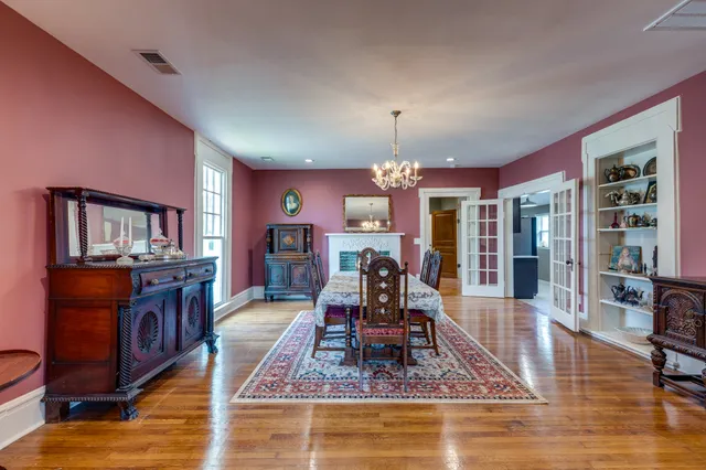 a view of a dining room with furniture a rug and wooden floor