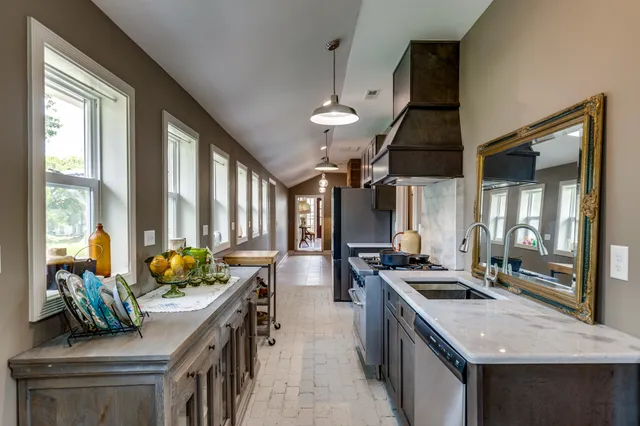 a kitchen with stainless steel appliances granite countertop a stove a sink and a refrigerator