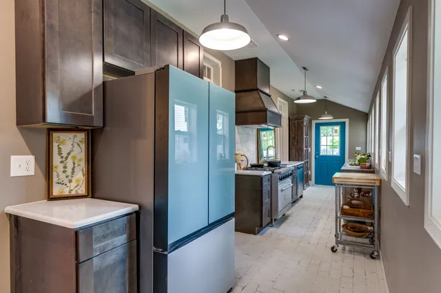 a kitchen with stainless steel appliances granite countertop a refrigerator a sink and a stove