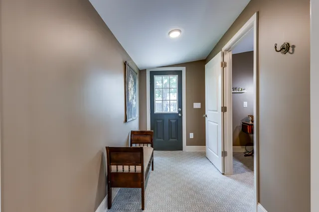 a view of a hallway with furniture and windows