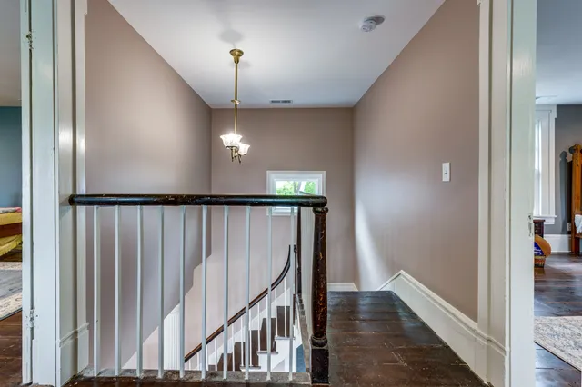 a view of a hallway with wooden floor and staircase