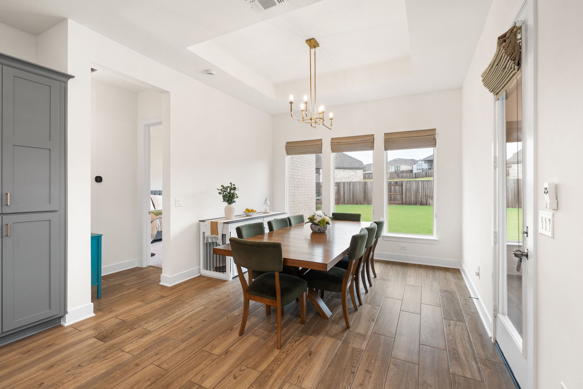 515 Watershield Cove Georgetown, TX 78633 - Photo 17 of 40 A refined dining space features a sophisticated tray ceiling and warm hardwood flooring.