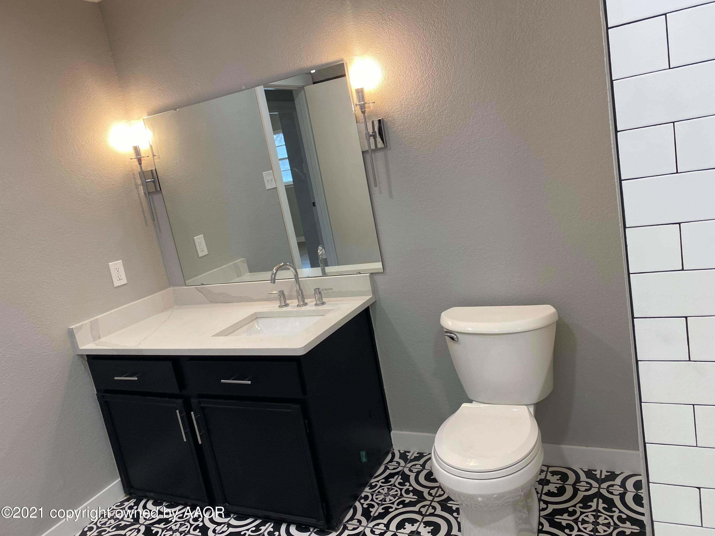 4304 South Bonham Street Amarillo, TX 79110 - Photo 9 of 9 a bathroom with a sink toilet and mirror