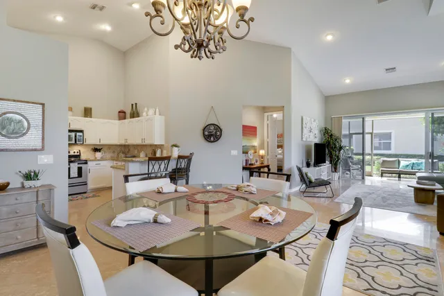 a dining room with furniture a rug and kitchen view
