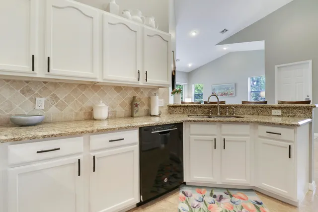 a kitchen with granite countertop white cabinets and white appliances