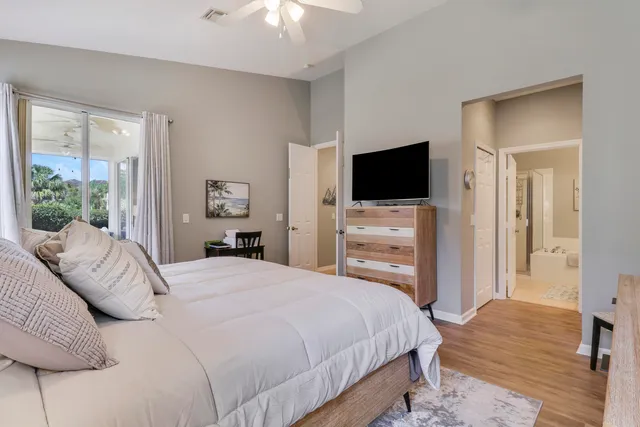 a bedroom with a bed and a flat tv screen on dresser