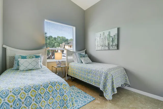 a bedroom with two beds and a window