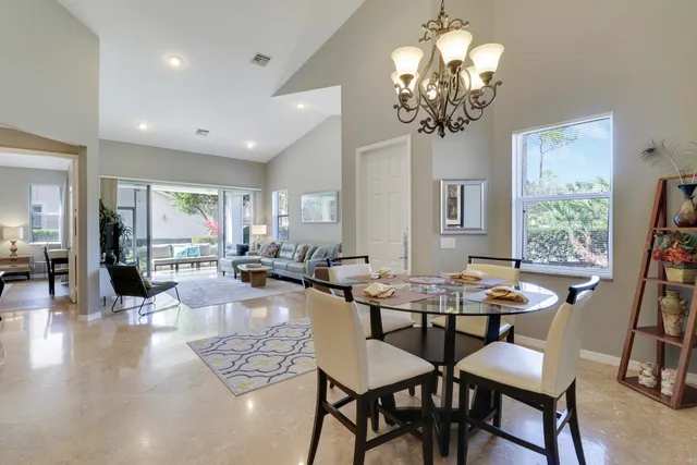 a dining room with furniture a chandelier and wooden floor