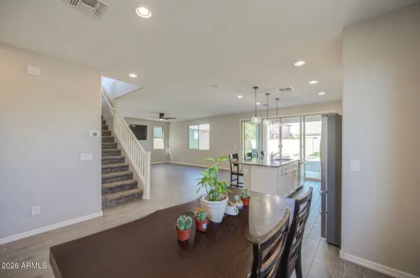 a kitchen with stainless steel appliances granite countertop a table chairs refrigerator and sink