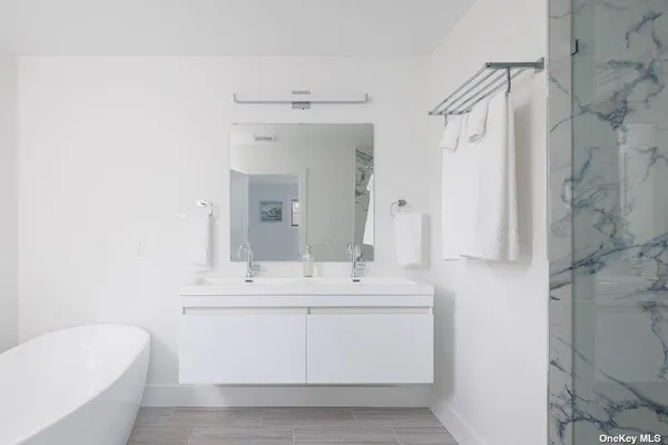 a bathroom with a sink vanity granite tub shower and a mirror
