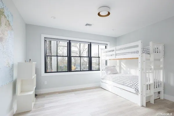 a view of a bedroom with wooden floor and a window