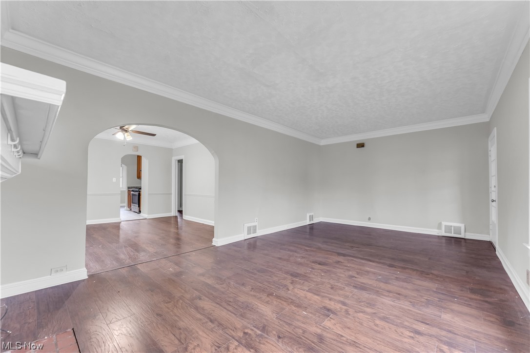 1499 Sherbrook Road South Euclid, OH 44121 - Photo 27 of 41 Empty room with ceiling fan, a textured ceiling, dark hardwood / wood-style flooring, and crown molding