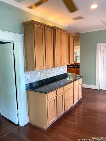 a kitchen with stainless steel appliances granite countertop a stove a refrigerator and wooden floor