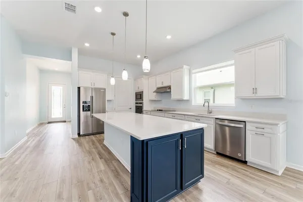 a kitchen with stainless steel appliances granite countertop a sink a stove and a refrigerator