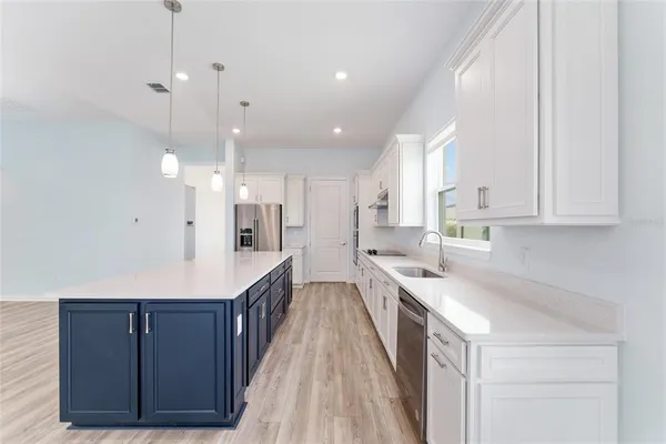 a large kitchen with a lot of counter space and wooden floor