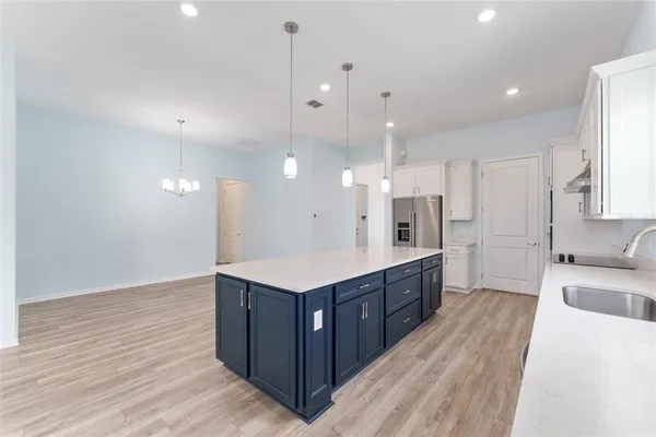 a kitchen with a stove and a wooden floor