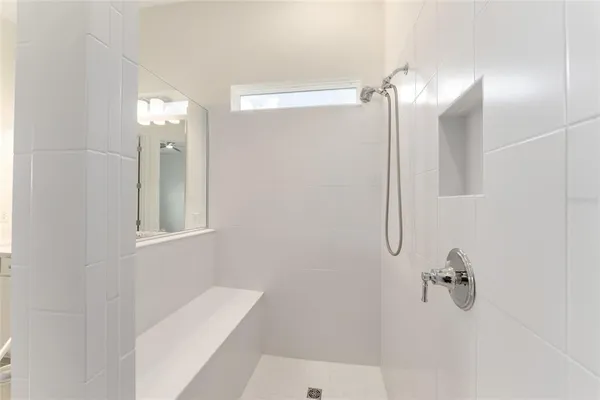 an empty room with wooden floor ceiling fan and windows