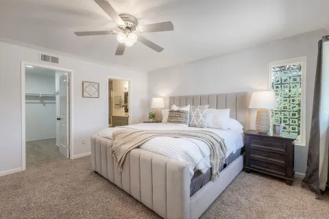 a bed room with a bed and a ceiling fan