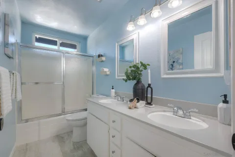 a bathroom with a double vanity sink mirror and toilet
