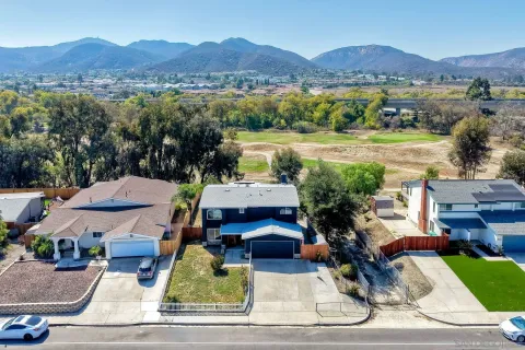 an aerial view of a house with yard swimming pool and mountain view