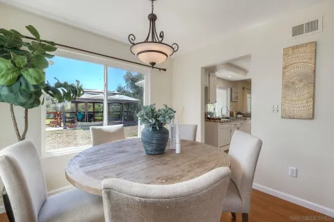 a dining room with furniture potted plants and wooden floor