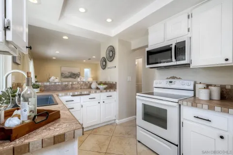 a kitchen with stainless steel appliances granite countertop a stove and white cabinets