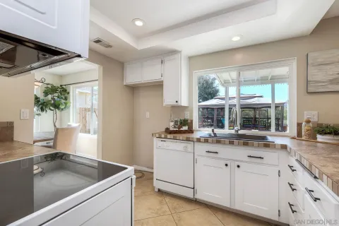 a kitchen with granite countertop a sink and white cabinets