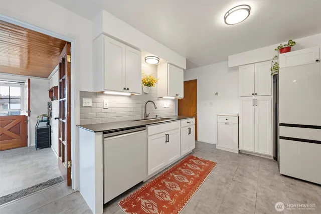 a kitchen with granite countertop a sink stove and refrigerator