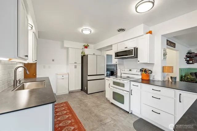 a kitchen with white cabinets sink and stainless steel appliances