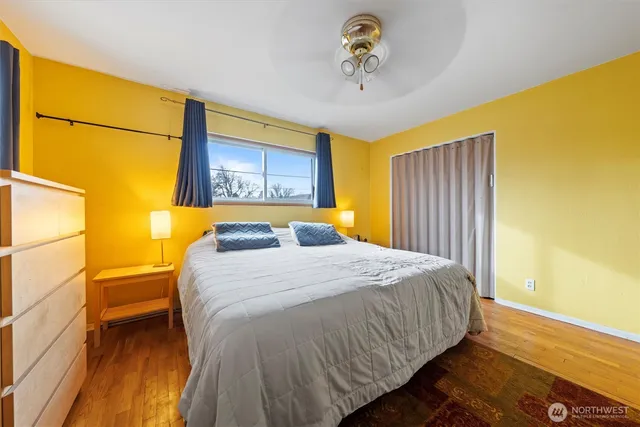 a bedroom with a bed and wooden floor