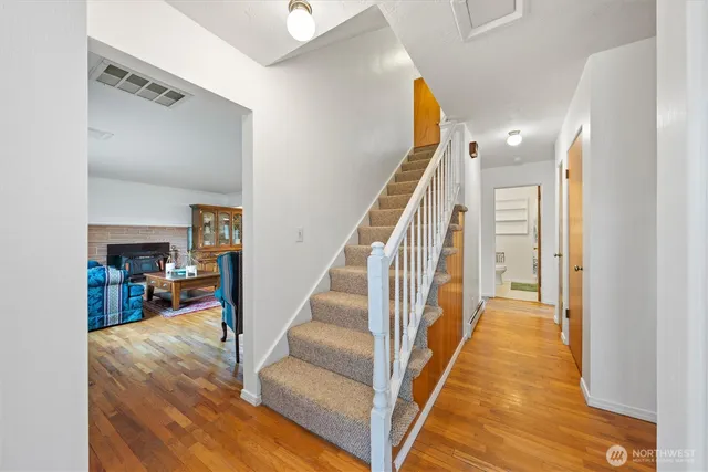 a view of a hallway with wooden floor and staircase