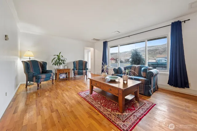 a living room with furniture a large window and a rug