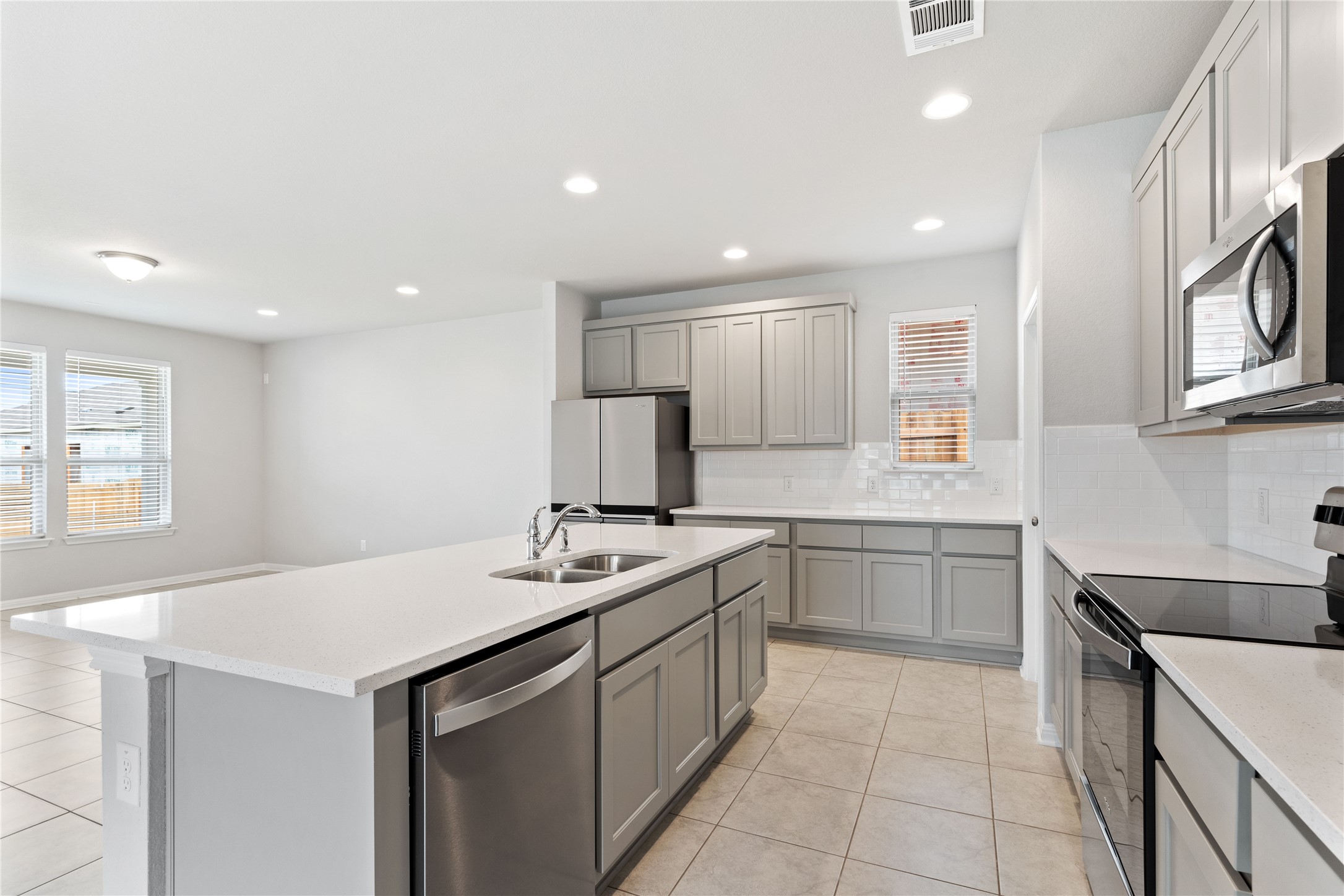 313 Mclintock Road Jarrell, TX 76537 - Photo 10 of 17 A well-appointed kitchen features a central island with a sink, sleek appliances, and ample cabinetry for culinary pursuits.