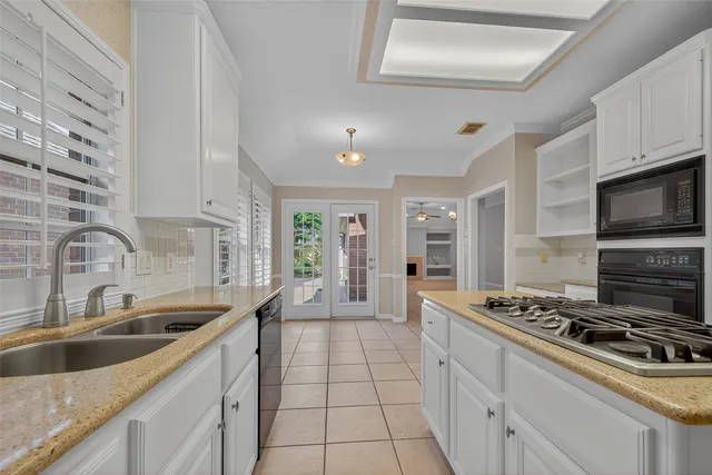 a kitchen with stainless steel appliances a sink a stove and cabinets