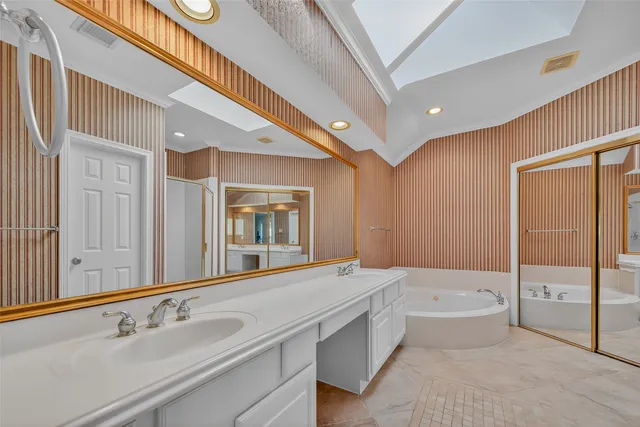 a bathroom with a tub a sink and mirror