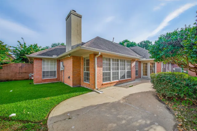 a front view of a house with a garden and yard