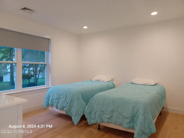 a bedroom with two beds and a potted plant