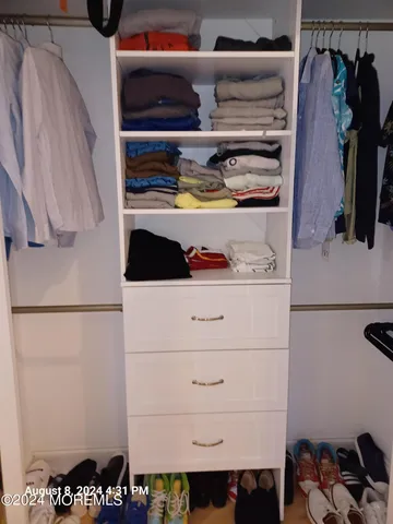 a view of walk in closet with clothes and shoes