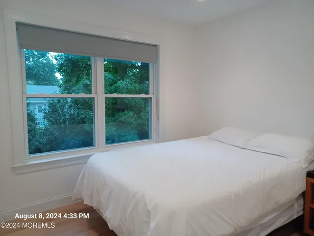 a large bed sitting in a bedroom next to a window
