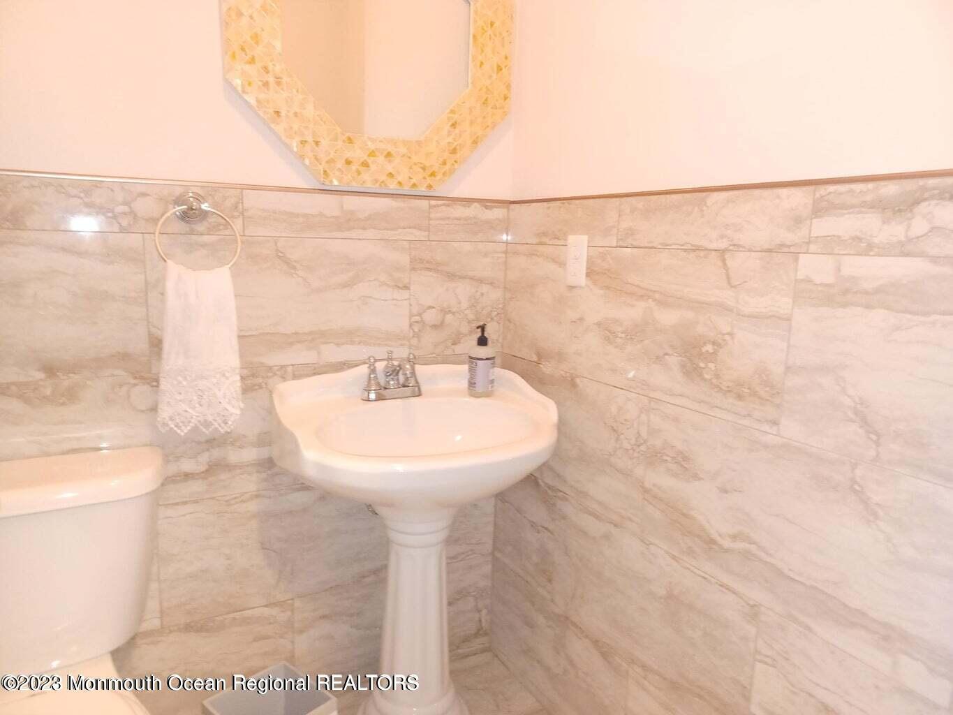 241 Woodcrest Road Oakhurst, NJ 07755 - Photo 18 of 19 a bathroom with a sink a mirror and shower