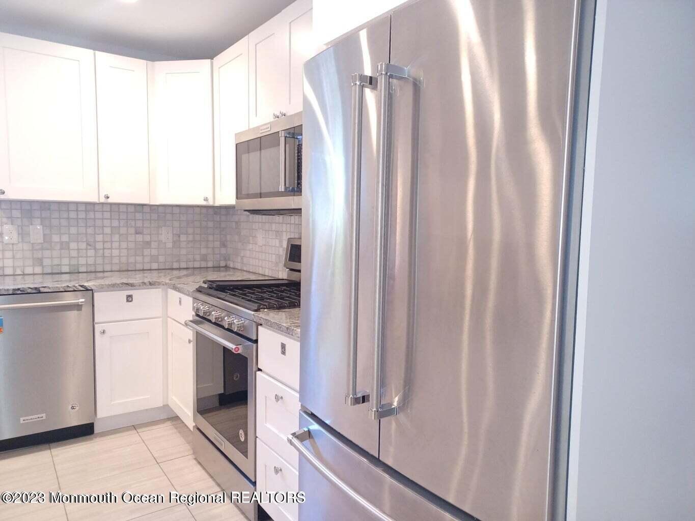 241 Woodcrest Road Oakhurst, NJ 07755 - Photo 6 of 19 a kitchen with stainless steel appliances a stove and a refrigerator