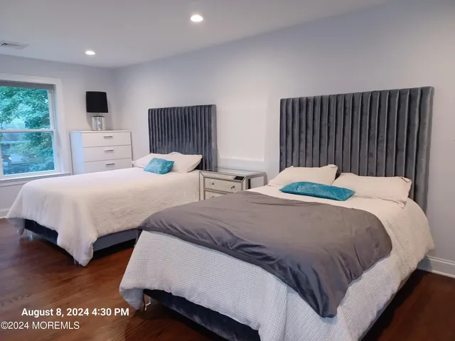 a bedroom with two beds and a large window