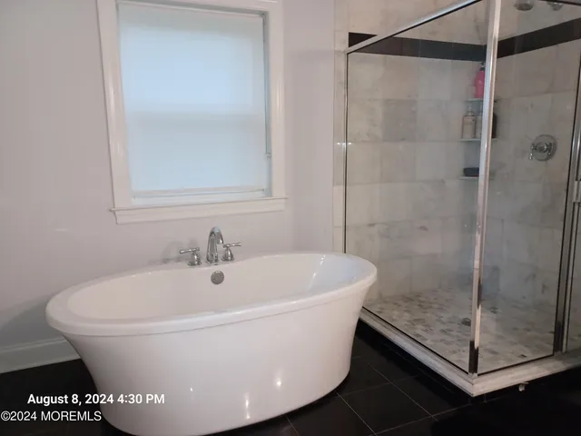 a white bath tub sitting next to a shower