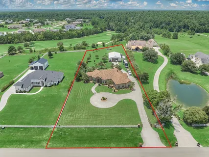 an aerial view of a golf course with a garden and houses