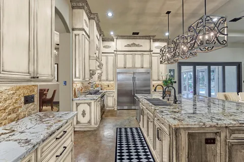 a kitchen with stainless steel appliances granite countertop a sink stove and refrigerator