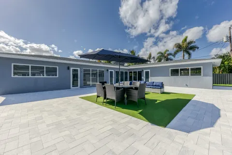 a view of a house with a yard and potted plants