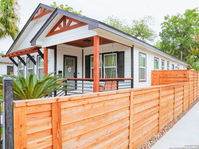 a view of a house with large windows and plants