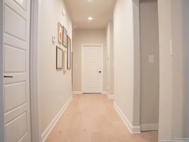 a view of a hallway with wooden floor